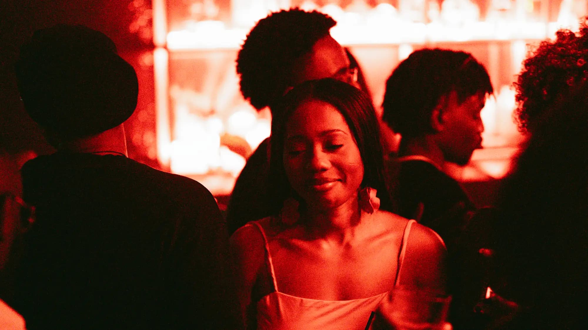 Invités devant le bar éclairé en rouge