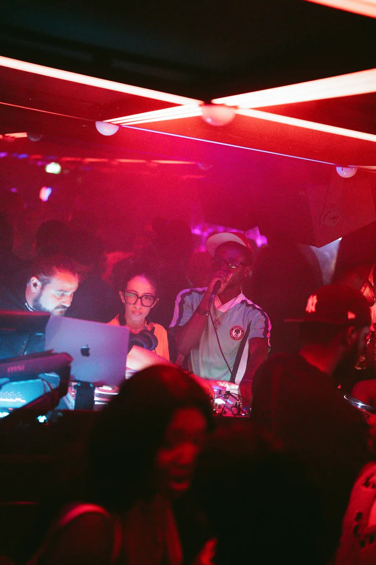 Les DJs derrière les platines, lumière rouge